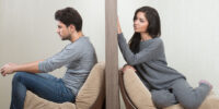 Conflict between man and woman sitting on either side of a wall